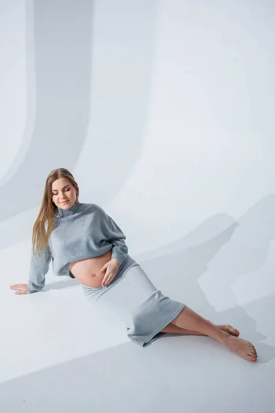 Linda Joven Embarazada Acariciando Vientre Sentado Sobre Fondo Blanco Mujer — Foto de Stock