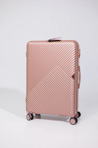白い背景に荷物を運ぶためのピンクのプラスチック製の強いスーツケース 旅行のための明るいスーツケース — ストック写真