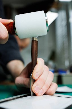 Profesyonel bir zanaatkarın elleri deri bir cüzdan yapar. Yeni, temiz, deri bir cüzdan, yakın plan kesilmiş bir fotoğraf..