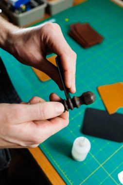 Ustanın elleri el yapımı deri ürünler dikiyor. Erkeklerin elleri parçaları birleştirir, kaliteli deri aksesuarlar yaratır. Deri atölyesinde çalışma süreci