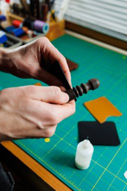 Ustanın elleri el yapımı deri ürünler dikiyor. Erkeklerin elleri parçaları birleştirir, kaliteli deri aksesuarlar yaratır. Deri atölyesinde çalışma süreci