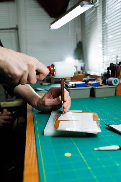 stock image Hands of a professional craftsman make a leather wallet new, clean genuine leather wallet, close-up cropped shot.