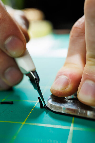 The hands of the master sew handmade leather products. Men's hands connect the parts, creating quality leather accessories. Working process in a leather workshop