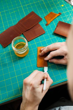 Doğal deriyle çalışan erkek ellerinin yakın çekimi. Gerçek deriden yapılmış el yapımı ürünler..