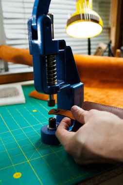 Efendinin el yapımı deri ürünlerini dikerken yakın plan çekimleri. Bir erkek tabakçısı parçaları birleştirir ve kaliteli deri aksesuarlar yaratır. Deri atölyesinde çalışma süreci