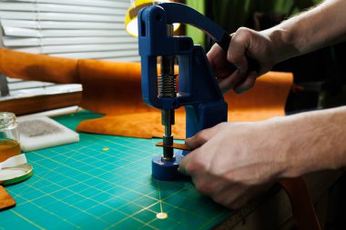 Efendinin el yapımı deri ürünlerini dikerken yakın plan çekimleri. Bir erkek tabakçısı parçaları birleştirir ve kaliteli deri aksesuarlar yaratır. Deri atölyesinde çalışma süreci