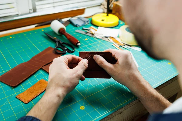 Close-up of male hands working with natural leather. Handmade products made of genuine leather.