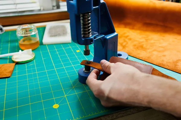 手作りの革製品を縫製するマスターの手のクローズアップ メンズタンナーは 品質の革アクセサリーを作成し 部品を接続します 革工房での作業工程 ストックフォト