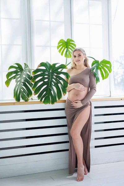 トップとスカートの中の美しい妊婦は彼女の腹を抱擁します スタイリッシュな妊婦 — ストック写真