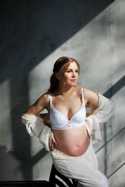 Una Joven Embarazada Con Estilo Traje Blanco Está Sentada Una — Foto de Stock