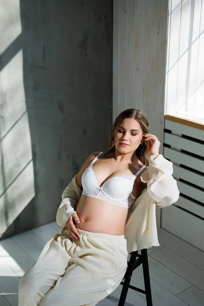 Mujer Joven Embarazada Con Estilo Traje Blanco Cerca Ventana Tocando — Foto de Stock