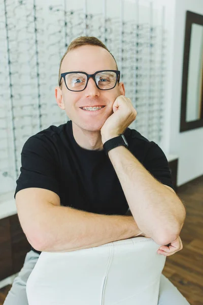 Ένας Νέος Χαμογελαστός Άντρας Επιλέγει Γυαλιά Για Διόρθωση Της Όρασης — Φωτογραφία Αρχείου