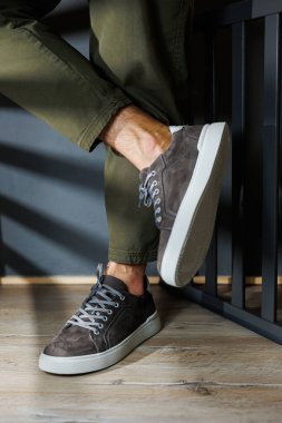 Erkek bacaklı, pantolonlu ve gri spor ayakkabılı. Erkek deri ayakkabıları. Erkeklerin şık yaz ayakkabıları koleksiyonu