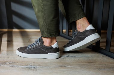 Erkek bacaklı, pantolonlu ve gri spor ayakkabılı. Erkek deri ayakkabıları. Erkeklerin şık yaz ayakkabıları koleksiyonu