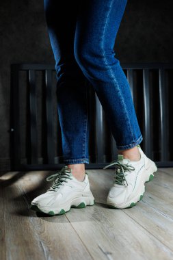 Kot pantolonlu kadın bacaklı beyaz deri spor ayakkabılar. Kadın ayakkabıları işte. Rahat kadın ayakkabıları.