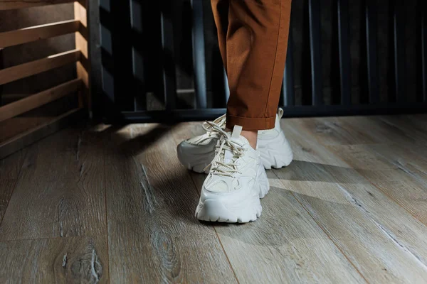 stock image Close-up of female legs in white leather sneakers with high soles. Collection of summer women's shoes. White women's sneakers with laces