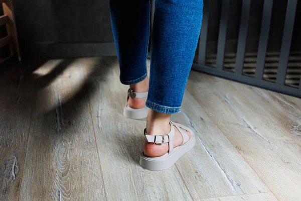 Όμορφα Λεπτά Γυναικεία Πόδια Δερμάτινα Σανδάλια Στο Πάτωμα Γκρι Παρκέ — Φωτογραφία Αρχείου
