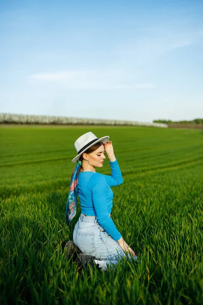 Молодая Привлекательная Женщина Белой Шляпе Голубой Рубашке Синих Джинсах Позирует — стоковое фото