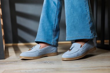 Kot pantolon ve mavi makosen ayakkabı giymiş ince kadın bacakları. Yazlık kadın ayakkabıları koleksiyonu. Yaz için şık kadın ayakkabıları.