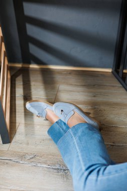 Kot pantolon ve mavi makosen ayakkabı giymiş ince kadın bacakları. Yazlık kadın ayakkabıları koleksiyonu. Yaz için şık kadın ayakkabıları.