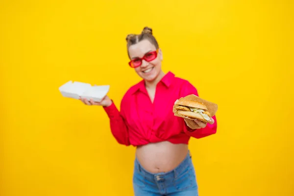 Vrolijke Zwangere Vrouw Roze Shirt Met Hamburger Geïsoleerde Gele Achtergrond — Stockfoto