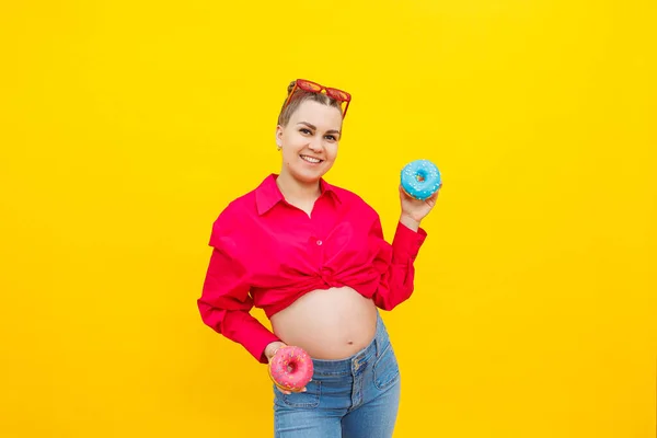 Una Mujer Embarazada Sonriente Con Una Camisa Rosa Sostiene Rosquillas —  Fotos de Stock