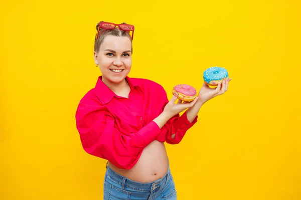 Una Mujer Embarazada Sonriente Con Una Camisa Rosa Sostiene Rosquillas —  Fotos de Stock