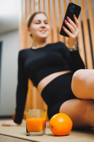 Een Glas Vers Geperst Sinaasappelsap Achtergrond Van Een Jonge Vrouw — Stockfoto