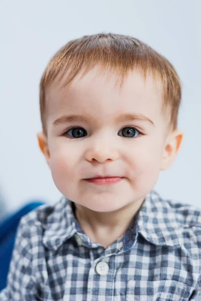 小さな男の子がチェックされたシャツの白い背景に1歳 彼の顔に笑顔の小さな子供 — ストック写真