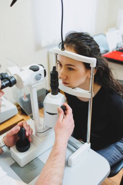 Modern optalmolojik ekipmanların vizyon incelemesi. Göz doktorunun randevusunda mikroskop kullanan bir kadının göz muayenesi. Göz doktoru randevusunda vizyon tedavisi
