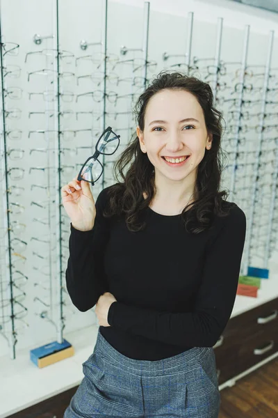 Μια Νεαρή Γυναίκα Διαλέγει Γυαλιά Ένα Κατάστημα Οπτικών Στάσου Όρθιος — Φωτογραφία Αρχείου