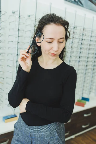Young Woman Chooses Glasses Optical Store Stand Glasses Vision Correction — Stock Photo, Image