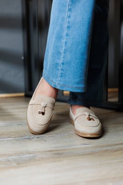 Kotlu kadın bacakları ve hakiki deriden yapılmış bej ayakkabılar..