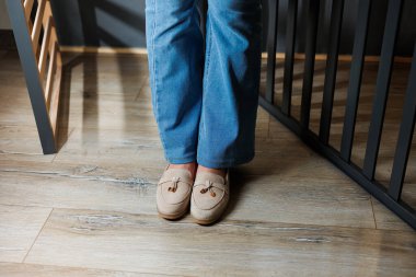 Kotlu kadın bacakları ve hakiki deriden yapılmış bej ayakkabılar..