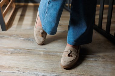 Kotlu kadın bacakları ve hakiki deriden yapılmış bej ayakkabılar..