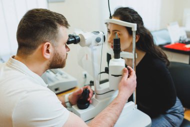 Modern optalmolojik ekipmanların vizyon incelemesi. Göz doktorunun randevusunda mikroskop kullanan bir kadının göz muayenesi. Göz doktoru randevusunda vizyon tedavisi