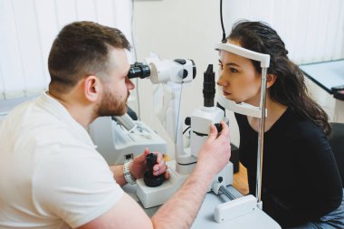 Modern optalmolojik ekipmanların vizyon incelemesi. Göz doktorunun randevusunda mikroskop kullanan bir kadının göz muayenesi. Göz doktoru randevusunda vizyon tedavisi