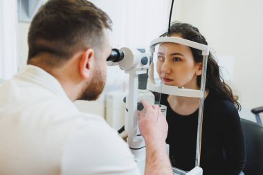 Modern optalmolojik ekipmanların vizyon incelemesi. Göz doktorunun randevusunda mikroskop kullanan bir kadının göz muayenesi. Göz doktoru randevusunda vizyon tedavisi