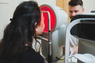 Modern optalmolojik ekipmanların vizyon incelemesi. Göz doktorunun randevusunda mikroskop kullanan bir kadının göz muayenesi. Göz doktoru randevusunda vizyon tedavisi