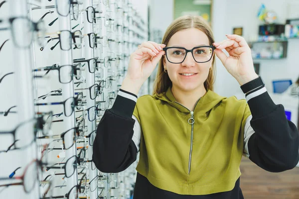 一个年轻的女人选择眼镜进行视力矫正 眼科诊所 配眼镜以改善视力 — 图库照片