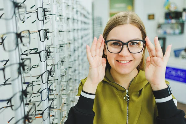 一个年轻的女人选择眼镜进行视力矫正 眼科诊所 配眼镜以改善视力 — 图库照片