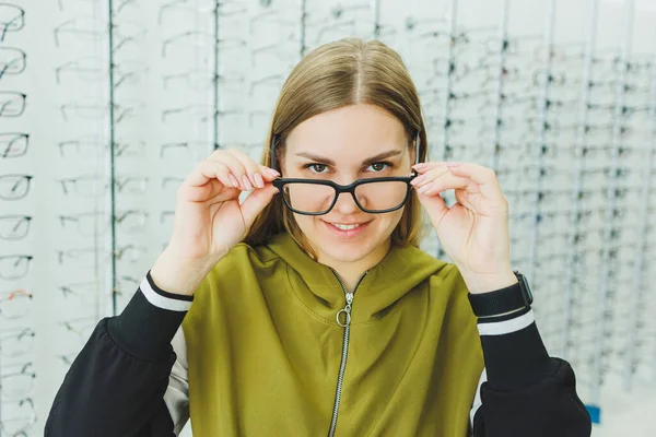 Uma Mulher Bonita Escolhe Óculos Uma Loja Oftálmica Uma Mulher — Fotografia de Stock