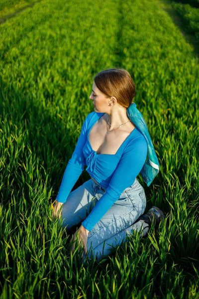 Eine Lächelnde Junge Frau Sitzt Auf Einem Weitläufigen Feld Grünen — Stockfoto