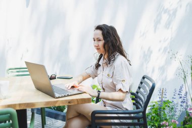 Laptopta yazan konsantre kız öğrenci kafede fincan ile çalışırken, düşünceli serbest yazar proje planlaması için bilgi yazar, dizüstü bilgisayarla uzaktan iş yapar.