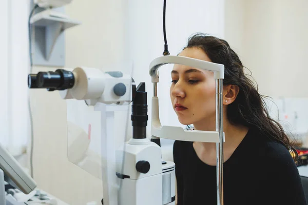 Examination of vision on modern ophthalmological equipment. Eye examination of a woman at an ophthalmologist\'s appointment using microscopes. Vision treatment at an ophthalmologist appointment