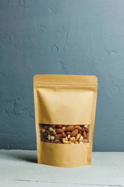 Roasted almonds in a cardboard kraft bag. Delicious peanuts.