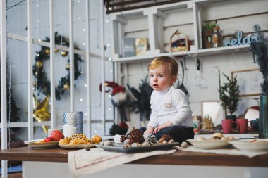 Evdeki Noel süslemelerinin arka planında gülümseyen bir çocuk. Ev Yeni Yıl atmosferi.