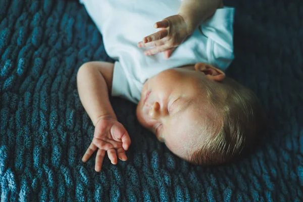 Uyuyan bir bebeğin portresi. Yeni doğmuş bir bebek uyuyor. Beyaz pamuklu bir elbise içinde bir bebek