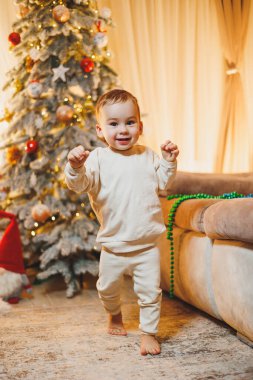 Küçük bir çocuk, 1 yaşında, Noel ağacını süslüyor. Yeni yıl. Noel ağacı.