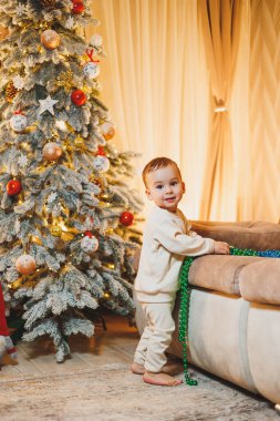 Küçük bir çocuk, 1 yaşında, Noel ağacını süslüyor. Yeni yıl. Noel ağacı.